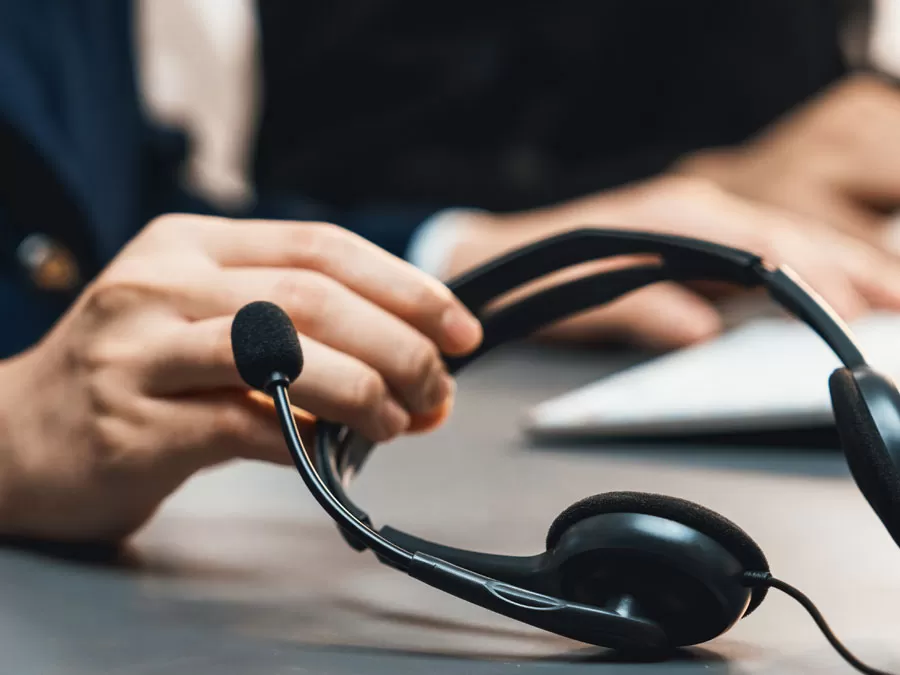 Enhancing Customer Experience depiction closeup hand holding call center headset