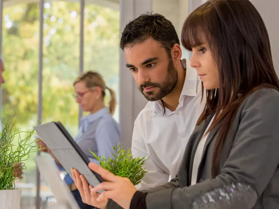 contact center agents in meeting reading document on tablet