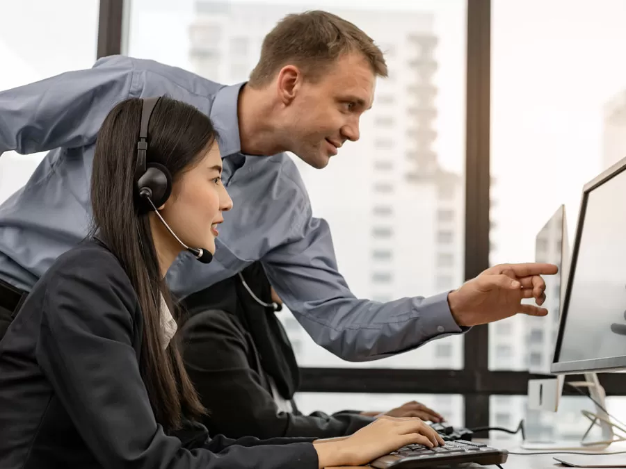 customer service agent receiving coaching from call center team leader