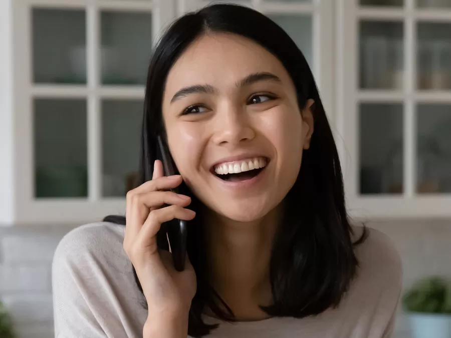 woman showing satisfying customer experience smiling on phone with call center